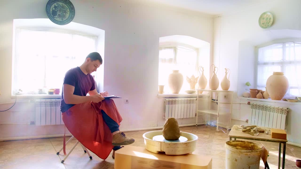 In a tranquil pottery studio, a skilled artisan captures inspiration while observing their crafting of unique ceramic pieces amidst soothing natural light