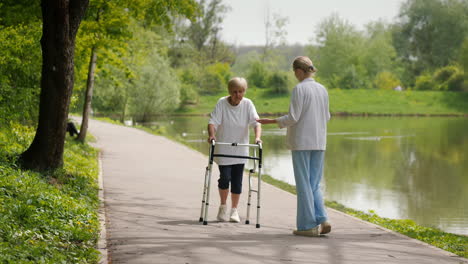 elderly woman with walker being assisted in a park