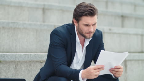 Businessman-working-with-documents-on-street.-Professional-reading-documents