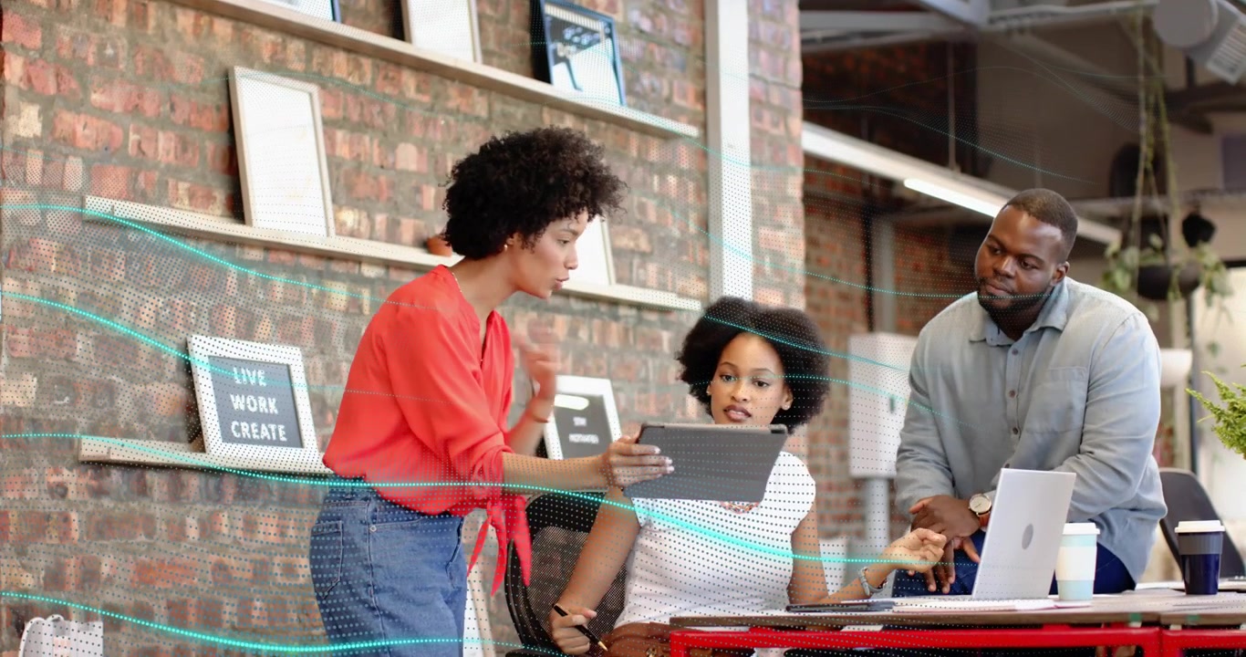 Presenter lifting tablet toward colleague and initiating business meeting while team jotting notes