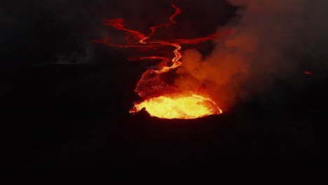 Forwards-fly-above-crater-of-active-volcano.-Erupting-hot-magma-and-outgoing-volcanic-gases.-Flowing-lava-streams-at-night.-Fagradalsfjall-volcano.-Iceland,-2021