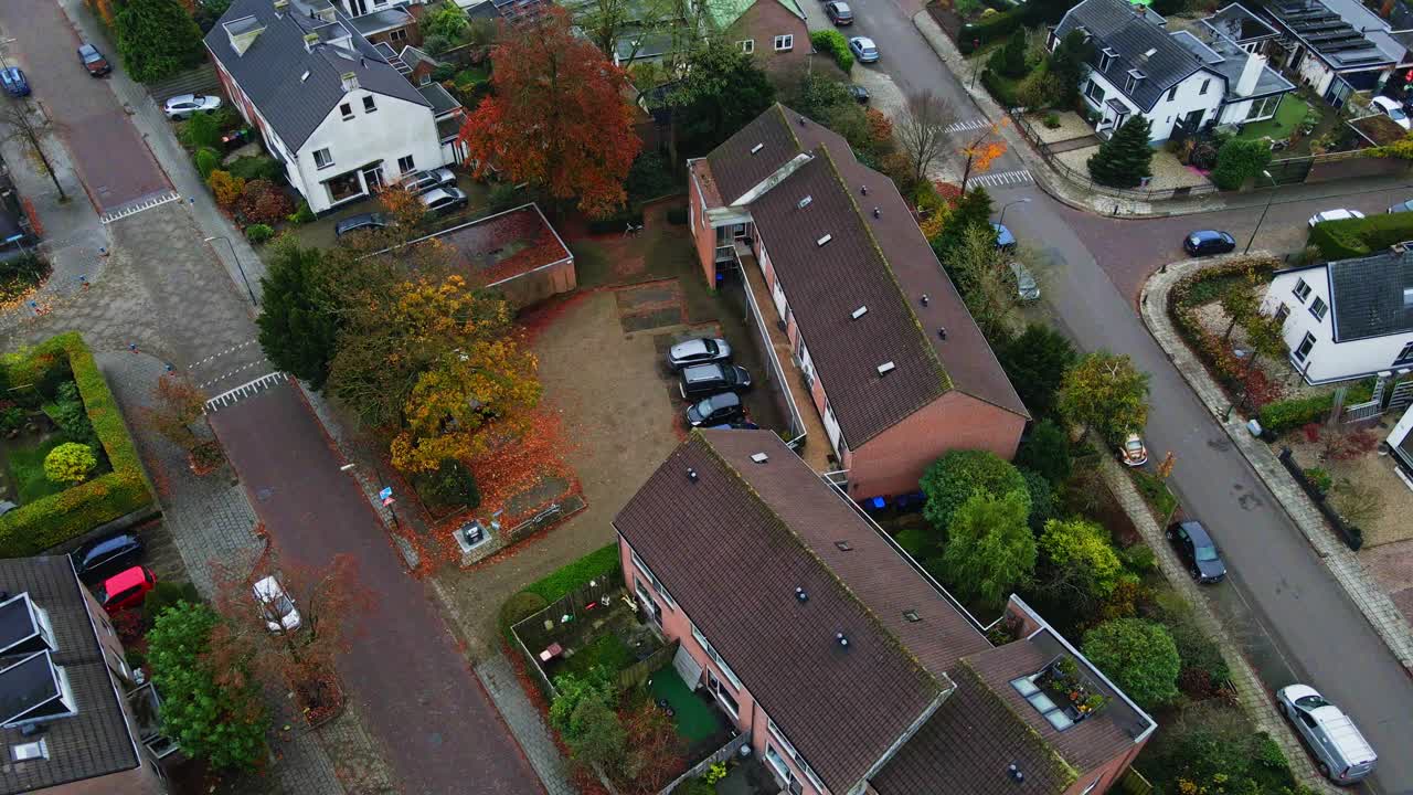 Jib down of a small apartment building in a quiet suburban neighborhood in a small, idyllic town on an overcast autumn day