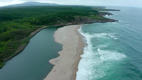 amazing aerial view of veleka beach with strong waves and calm river during a cloudy day