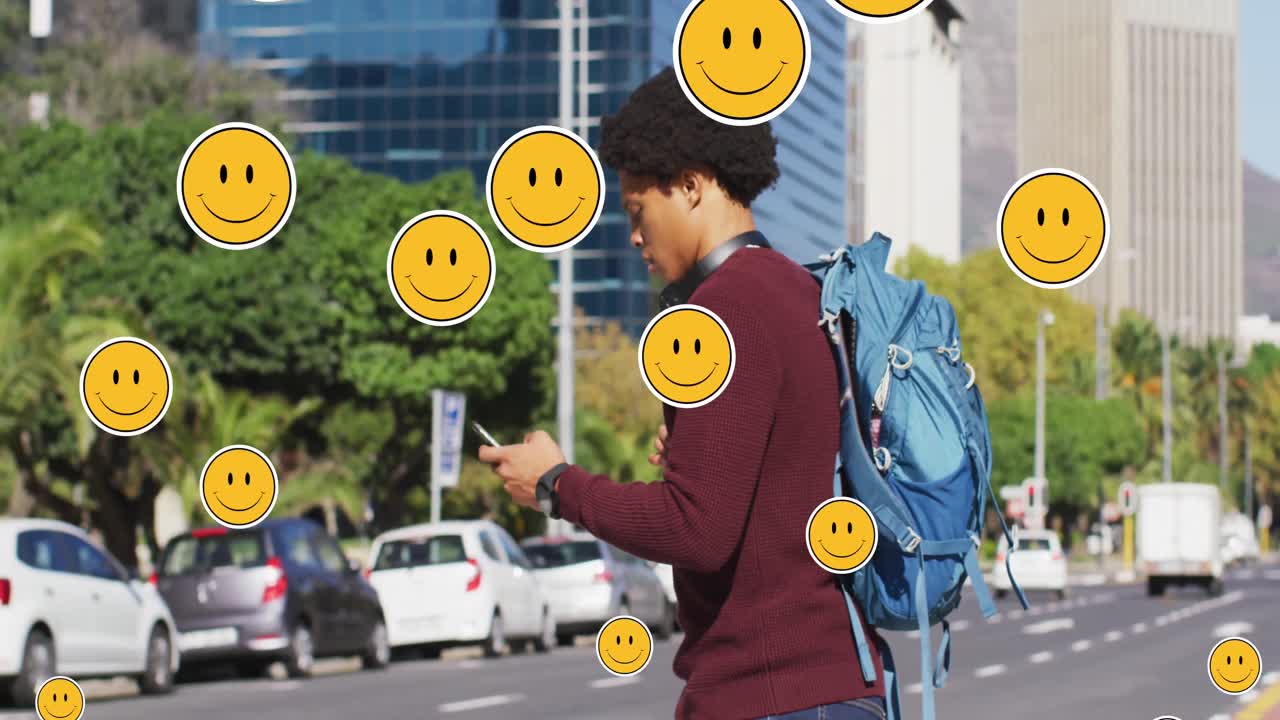 animación de iconos emoji sobre un hombre afroamericano que usa un teléfono inteligente