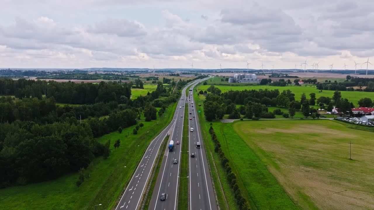 Long highway stretch near Pasłęk captured by drone with fields and turbines