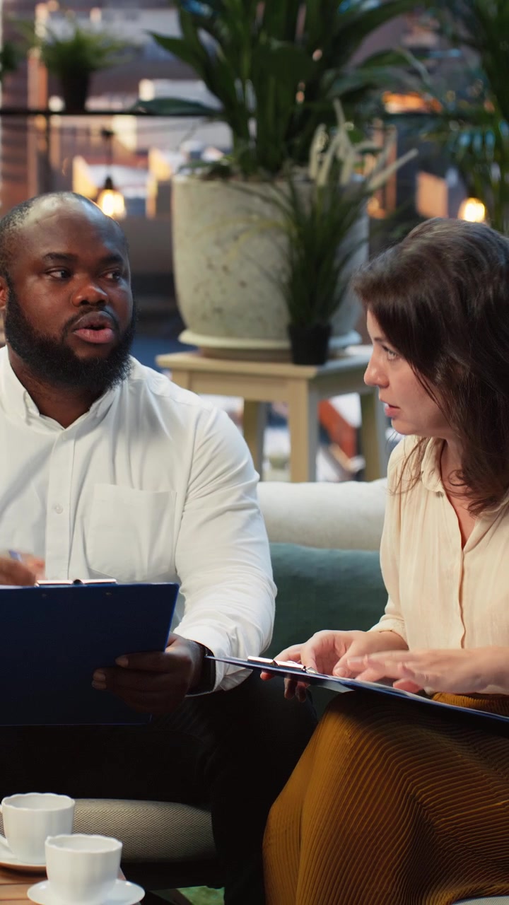 Vertical video Businesspeople analyzing project documents, talking during networking event