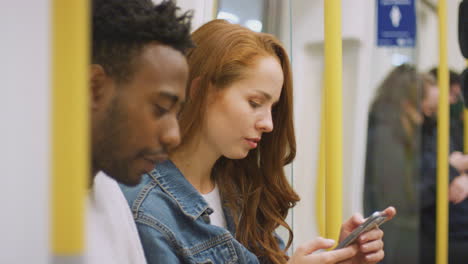 una joven pareja de vloggers o influencers sociales viajando por la ciudad en el metro para las redes sociales