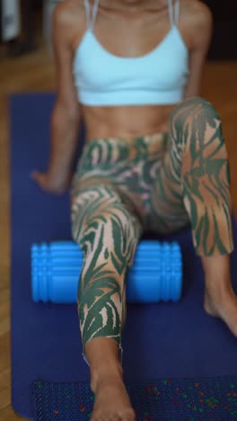 woman using a foam roller for leg stretch