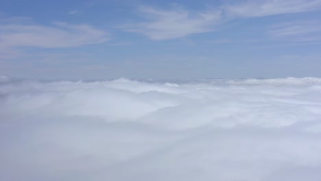 A-stunning-drone-shot,-a-drone-flying-among-the-clouds-at-high-altitude,-California