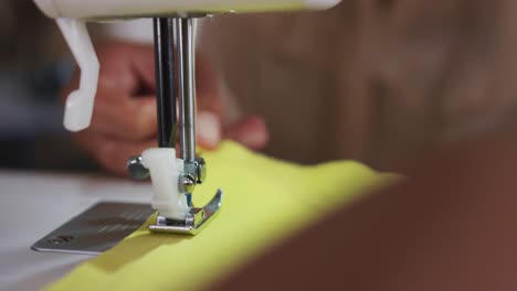 mujer de raza mixta cosiendo en una oficina de moda