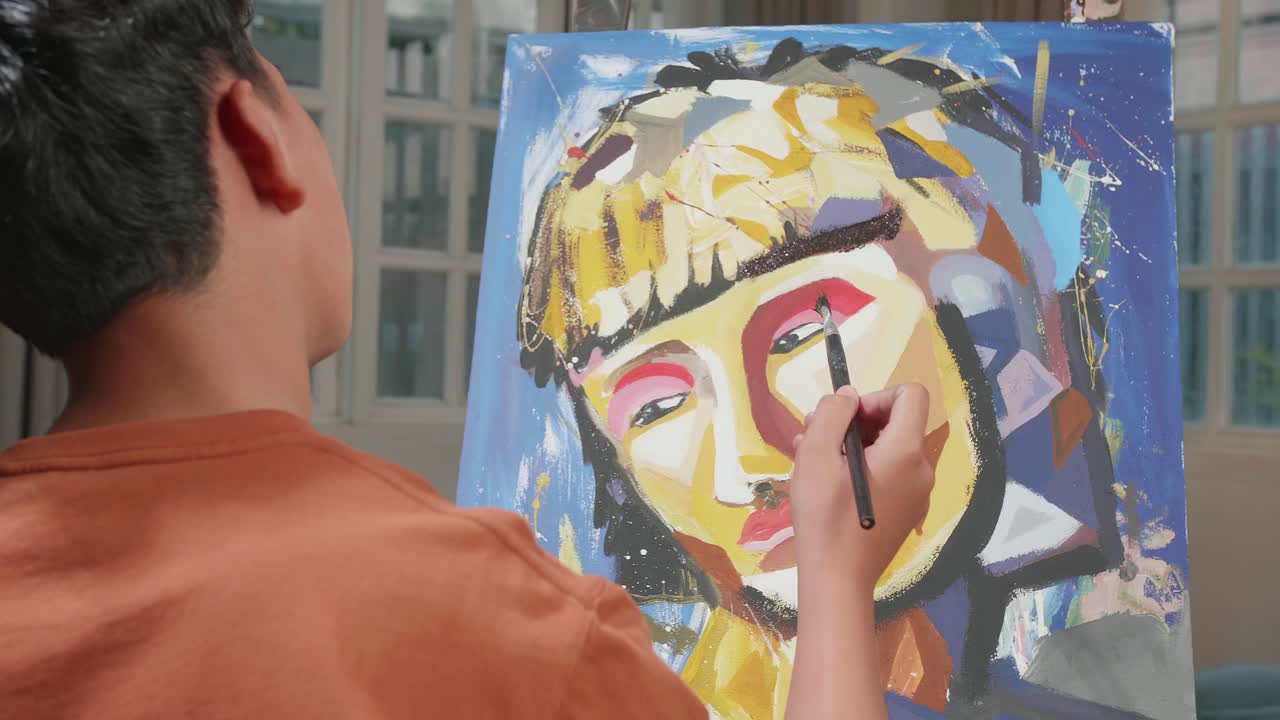 Hind View Of An Asian Artist Boy Holding Paintbrush Mixed Colour And Thinking Before Painting A Girl'S Hair On The Canvas