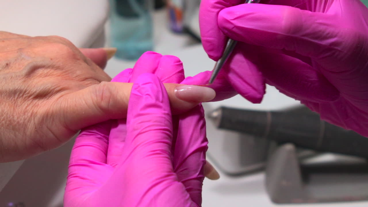Applying Nail Polish with Pink Gloves