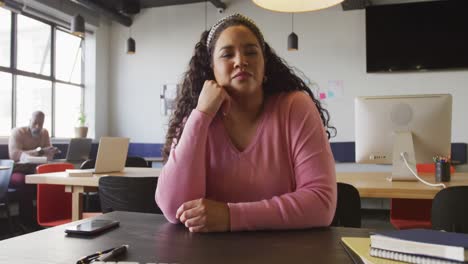 Portrait-of-biracial-businesswoman-with-arms-crossed-looking-at-camera-at-office