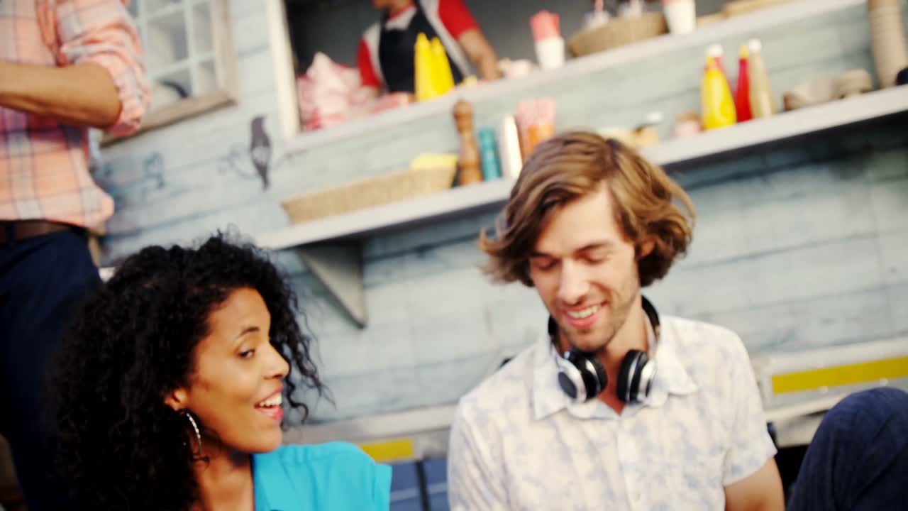 grupo de amigos brindando una botella de cerveza mientras comen