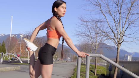 Athletic-young-woman-stretching-legs-before-morning-run-Medium-shot