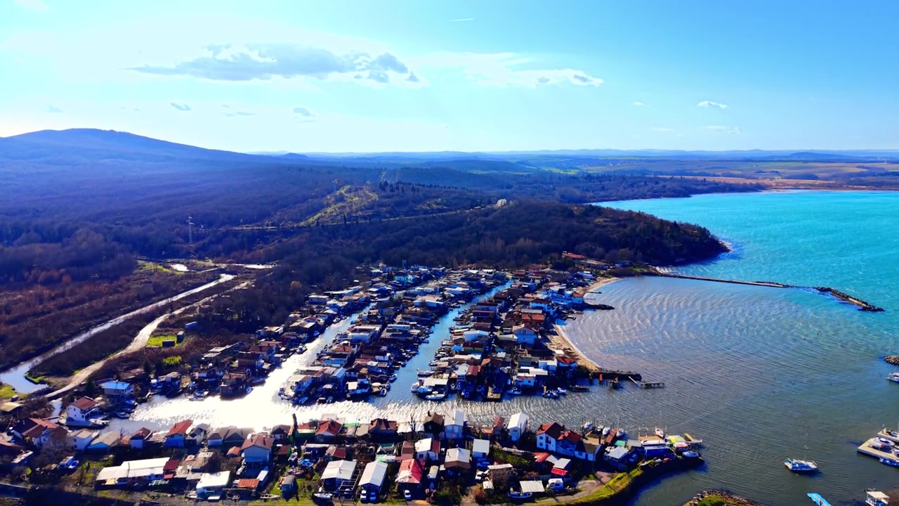 Forhøjet droneudsigt over et grønt parklandskab, der fører til kystnære vandkanaler. Panoramaudsigt over fiskelandsbyen Chengene Skele, Burgas, Bulgarien