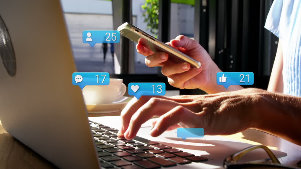 Animation of social media icons falling over person using laptop