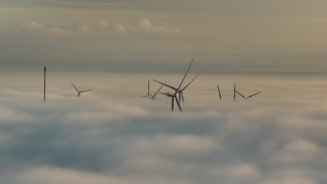 aerial drone shot of wind turbines above the clouds