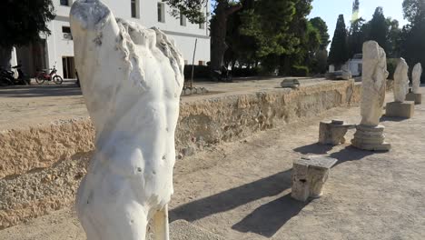 Marble-statue-fragment-at-ancient-Roman-ruins-in-Carthage,-sunlight-casting-shadows