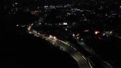 Hochwinkelaufnahme,-Die-In-Einer-Dunklen-Nacht-Die-Verkehrsbewegung-Entlang-Einer-Mexikanischen-Dorfstraße-Zeigt