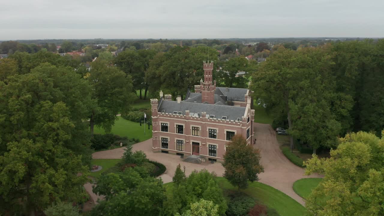 무성한 녹색 부지에 있는 아름다운 옛 저택의 공중 개요