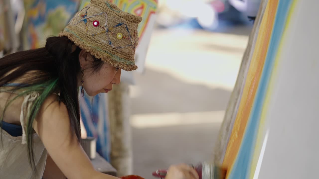 Woman painting on a canvas outdoors