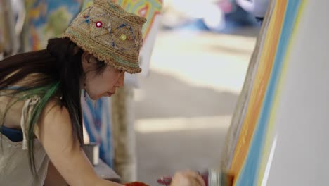 woman painting on a canvas outdoors