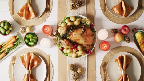video de bandeja con pavo asado, platos diversos y decoración de otoño en superficie blanca