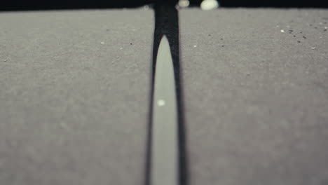 close-up view of water droplets on a gray surface.
