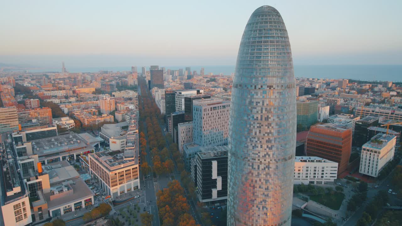 vista aérea de un moderno edificio de vidrio en la ciudad de barcelona junto al mar