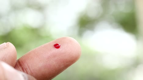 young mans hand measure glucose level at home