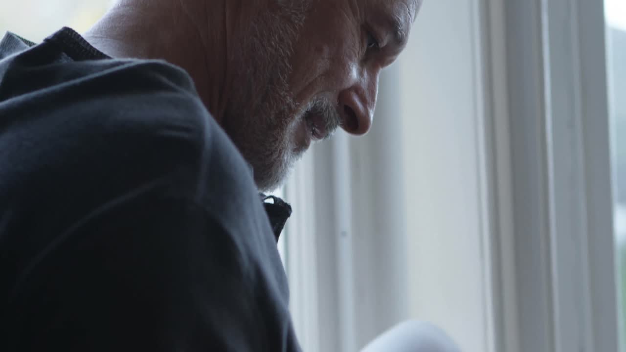 Senior man using mobile phone at home 4k