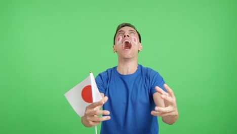 man cheering for japan screaming and waving a national flag
