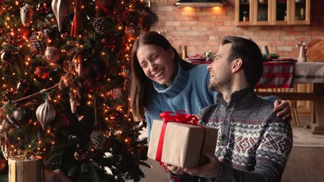 smiling young 30s woman giving present to husband.