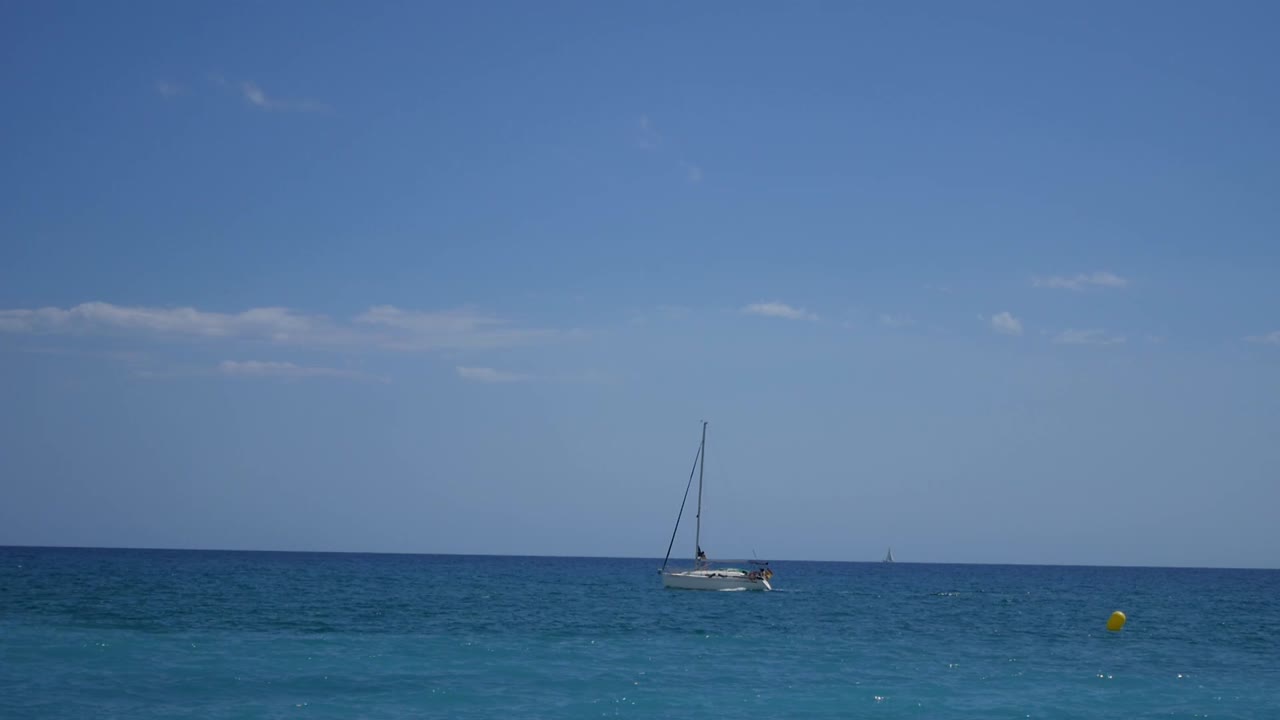 relajante escena de yate navegando en el horizonte del mar con pocas nubes detrás
