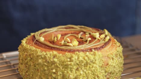 pistachio croissant donut being decorated covering with pistachio pieces