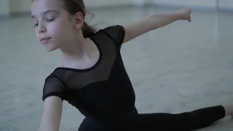 young ballerina practicing dance moves in studio