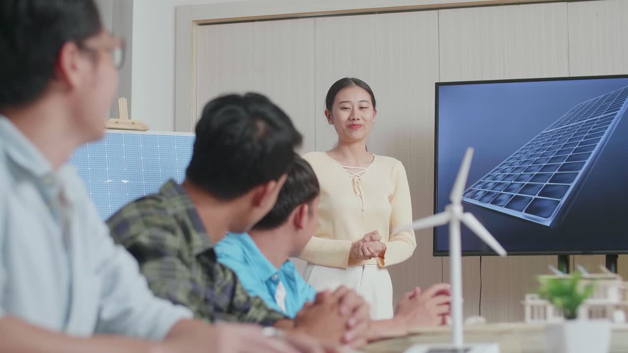 아시아 여성 엔지니어가 사무실에서 태양전지 작업에 대해 성공적으로 발표하면서 관객들은 박수를 치며 인상적 느낌을 받았습니다.