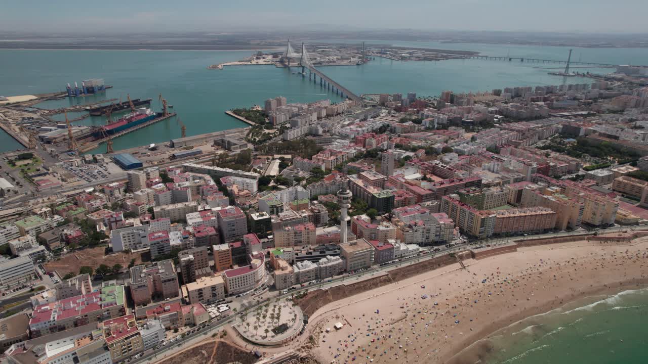 drone aéreo hacia adelante e inclinado hacia arriba toma de la ciudad de cádiz con vista a puente de la constitución, zona costera del puerto, cádiz, españa