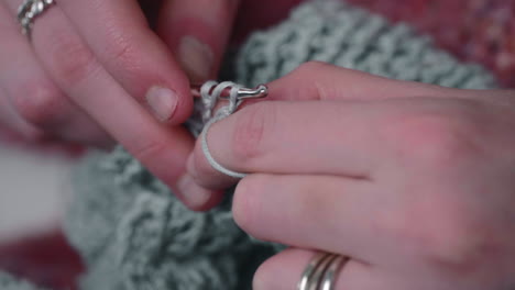 female hands knitting with crochet hook and yarn - close up