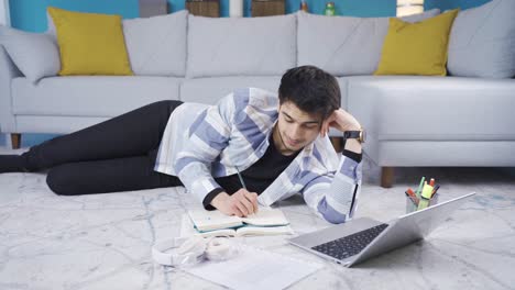 joven alegre estudiando relajado en casa acostado.