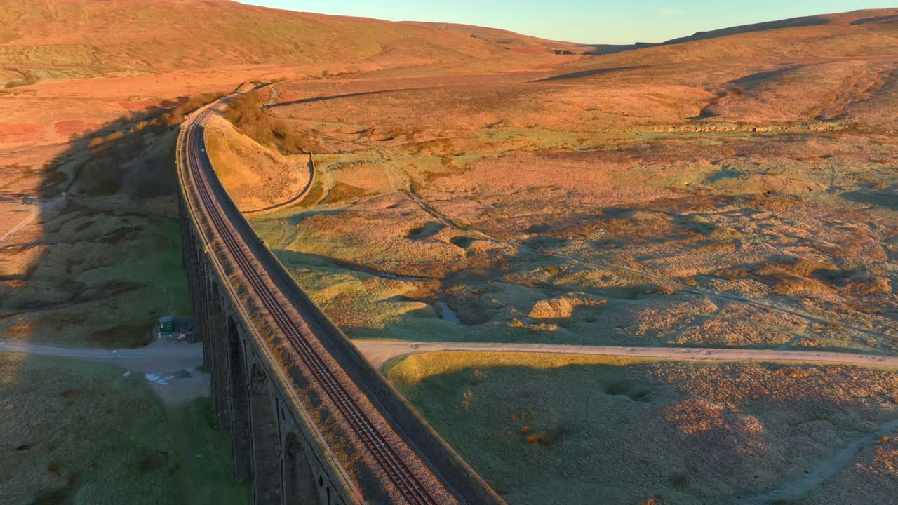 puente ferroviario de una sola vía que atraviesa el paisaje de páramo de invierno al amanecer