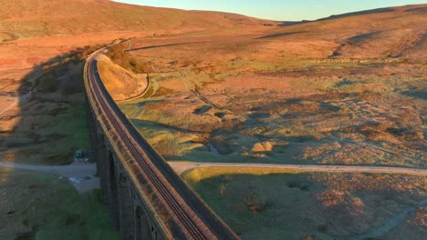 Eingleisige-Eisenbahnbrücke-überspannt-Die-Winterliche-Moorlandschaft-Bei-Sonnenaufgang