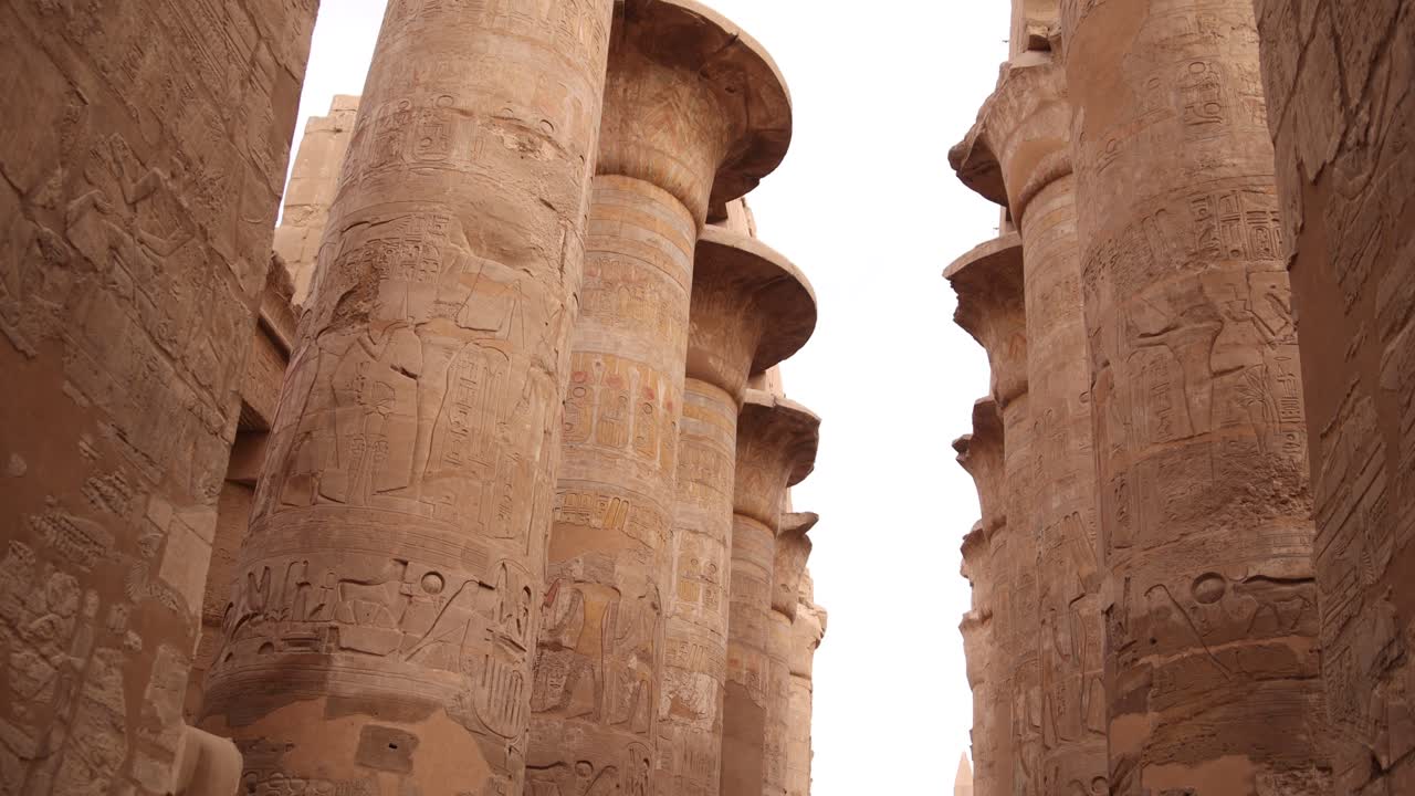 foto panorámica de altas columnas llenas de jeroglíficos en la sala hipóstila del templo de karnak en luxor, egipto