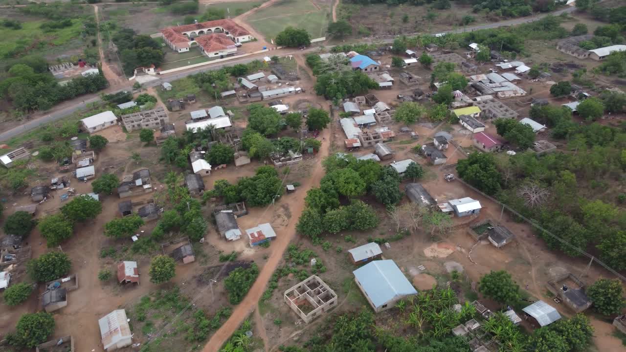 Filmato aereo di un drone del Ghana, Africa, lago sereno circondato da montagne. Imbarcazioni tradizionali sull'acqua vicino a un villaggio locale, con viste vicino alla Right to Dream Football Academy.
