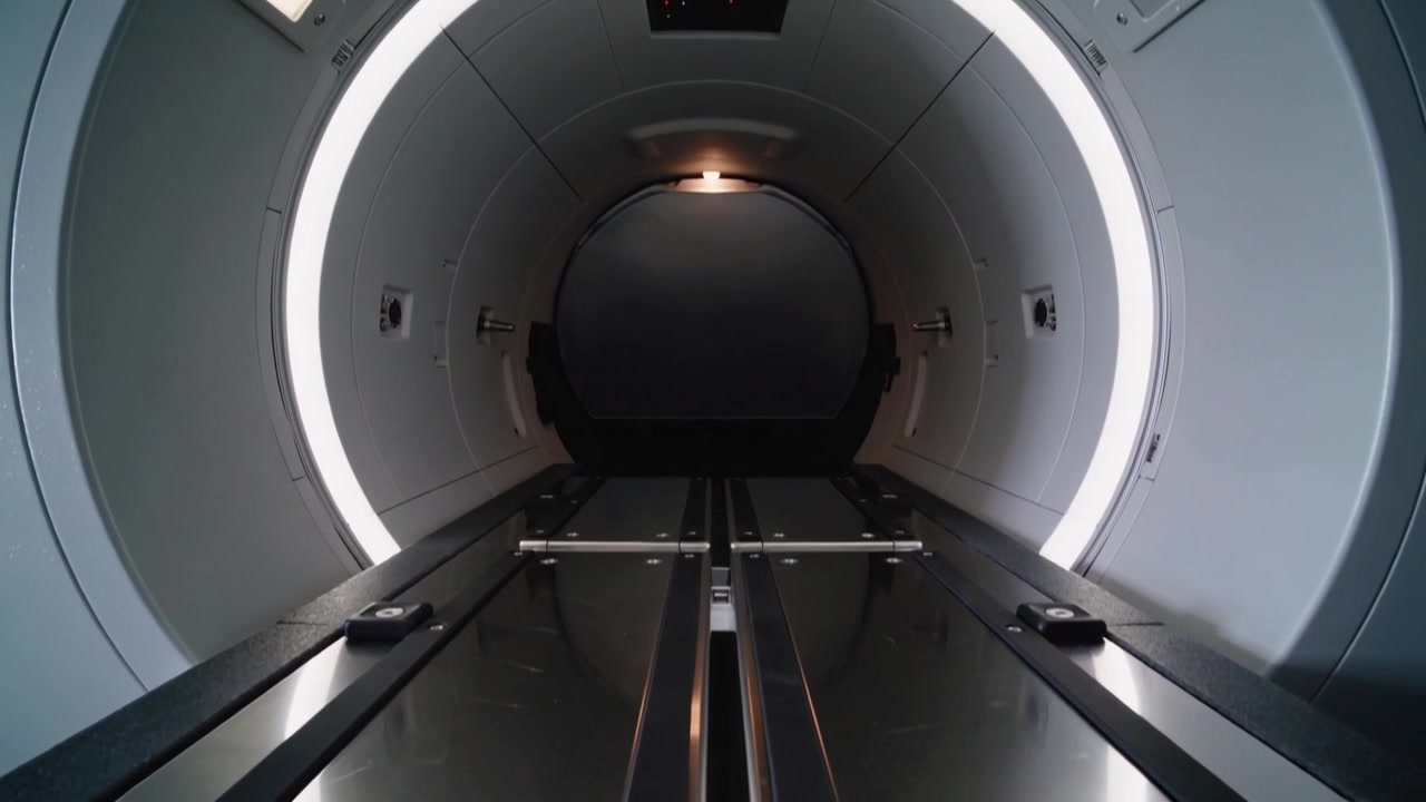 Il motore si avvia, il lettino del paziente scorre lungo i binari nell'apertura dello scanner per l'acquisizione di immagini, l'anello si illumina.
