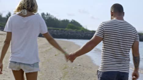 boyfriend and girlfriend walking on beach