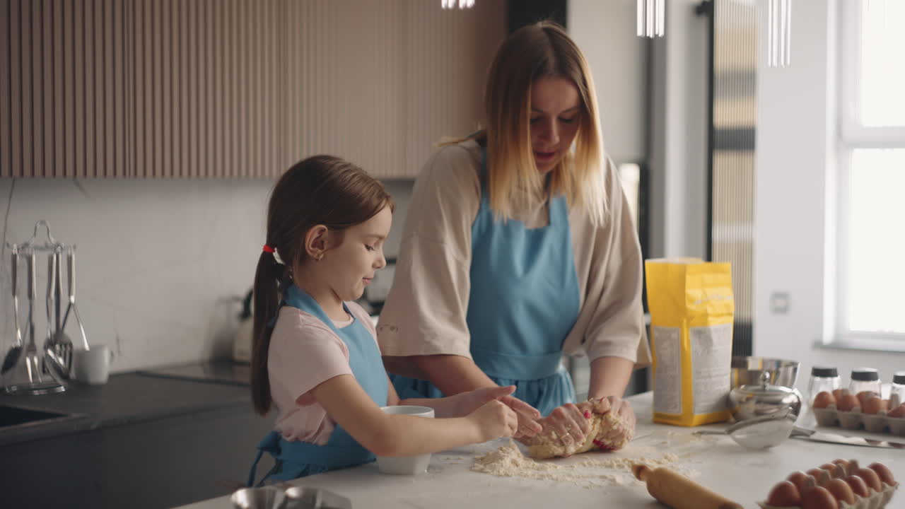 cocina en casa mujer y niña están haciendo masa para pan o pastel en la cocina de la casa la madre está amassando