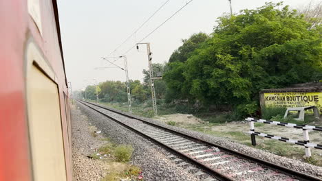 lucknow, india - 12 may 2023: looking out the window as the train moves forward through the indian suburbs