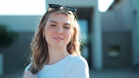 beautiful young small woman running towards modern building and smiling at camera